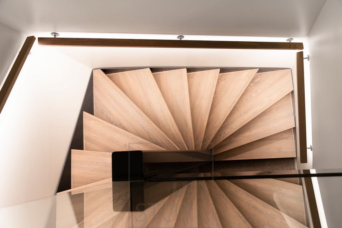 Indirect atmospheric lighting of the stairs implemented with a LED strip on the handrail.